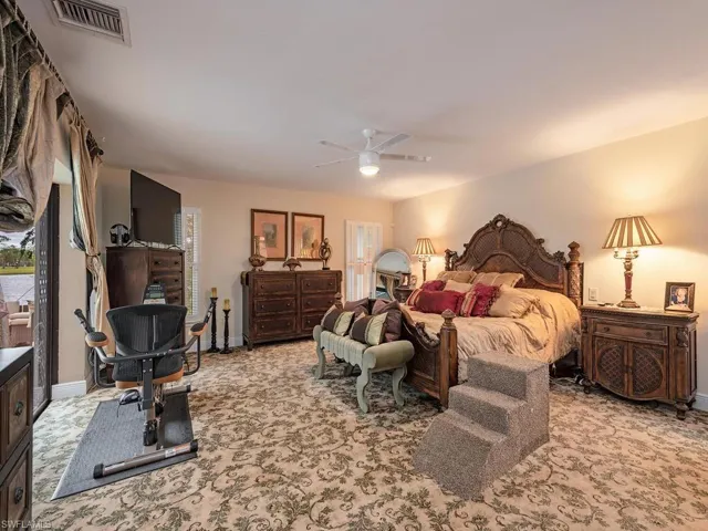 Bedroom with ceiling fan and light colored carpet