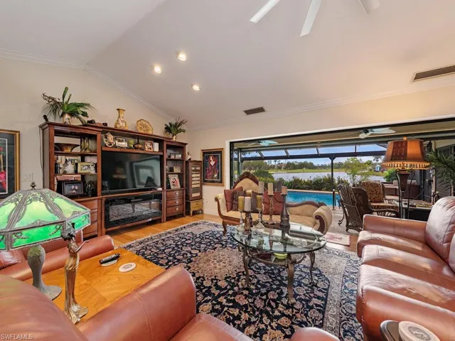 Living room with vaulted ceiling, ceiling fan, light hardwood / wood-style flooring, and crown molding