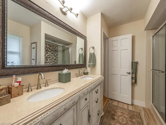 Bathroom with vanity, a shower with shower door, and hardwood / wood-style floors