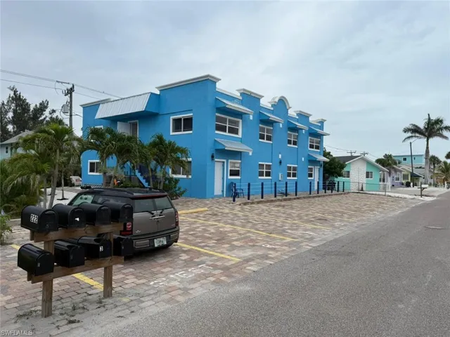 View of building exterior featuring uncovered parking