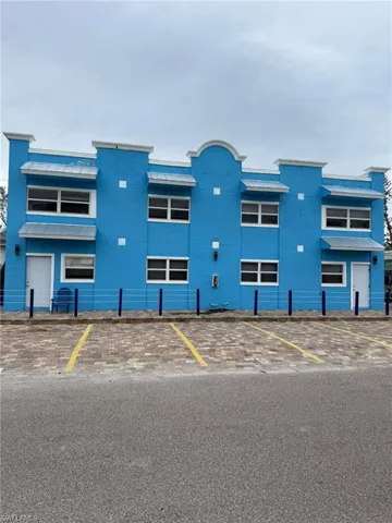 View of building exterior featuring uncovered parking