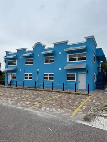 View of building exterior with uncovered parking