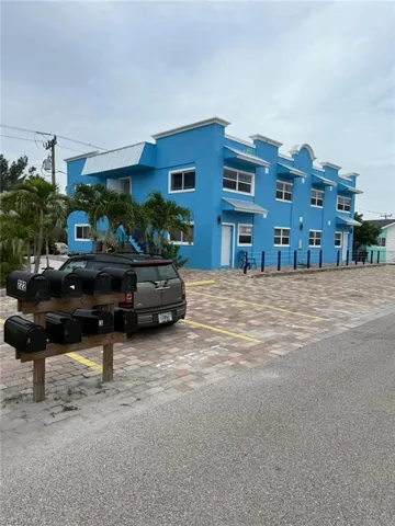 View of building exterior with uncovered parking