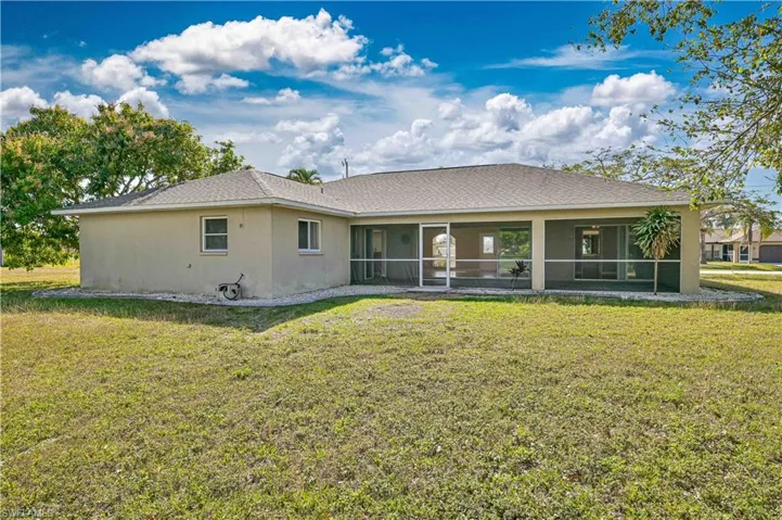 Back of house featuring a sunroom and a yard