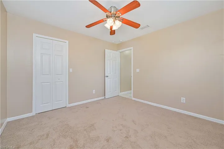 Unfurnished bedroom with light carpet, a closet, and ceiling fan