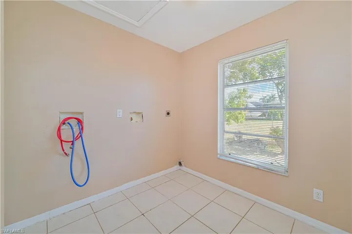 Laundry area featuring hookup for a washing machine, electric dryer hookup, and light tile patterned floors