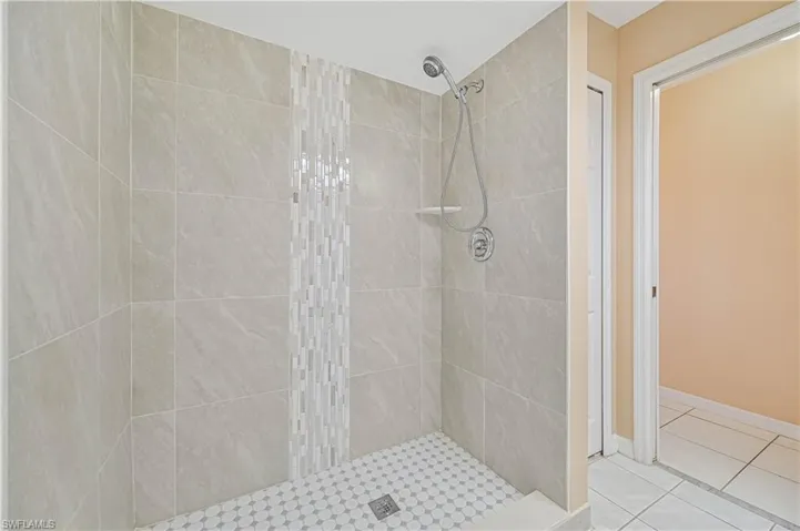 Bathroom featuring tile patterned floors and a tile shower