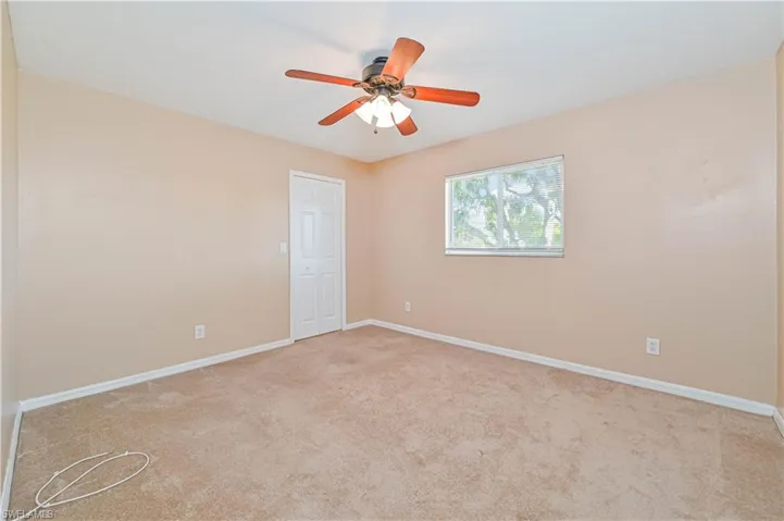 Spare room with ceiling fan and light carpet