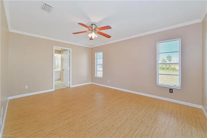 Empty room featuring ornamental molding, light hardwood / wood-style floors, and ceiling fan