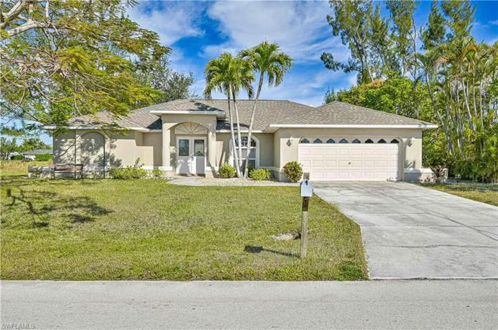 Single story home with french doors, a garage, and a front lawn