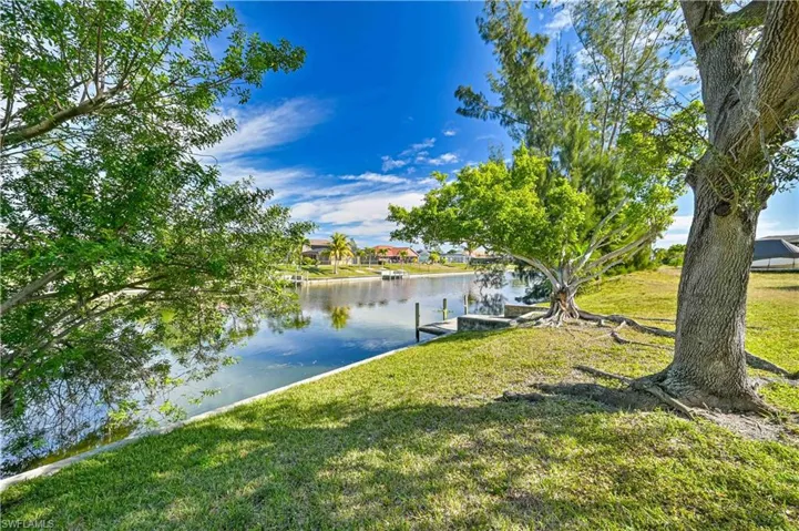 Dock area with a water view and a yard
