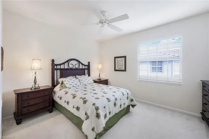 Bedroom with a ceiling fan and light carpet