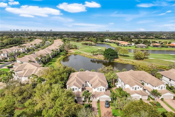 Aerial view of residential area with a local golf course and a nearby body of water