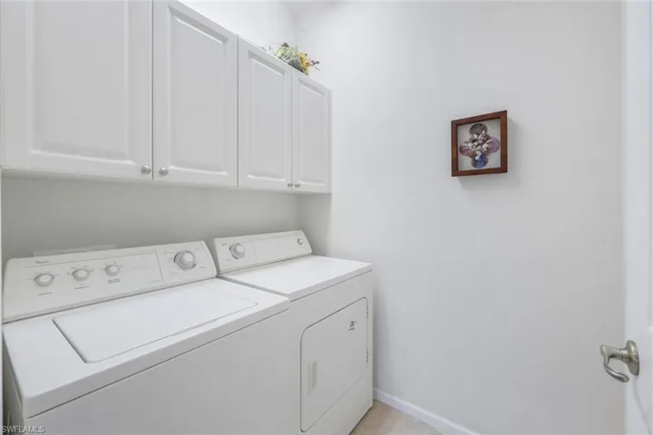 Washroom featuring cabinet space and washing machine and clothes dryer