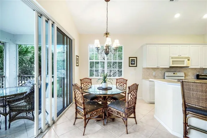 Dining room with a chandelier, light tile patterned flooring, and recessed lighting