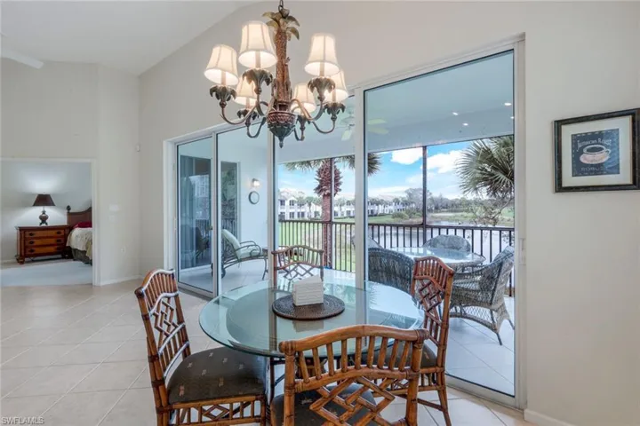Dining room featuring light tile patterned floors, a water view, and a chandelier