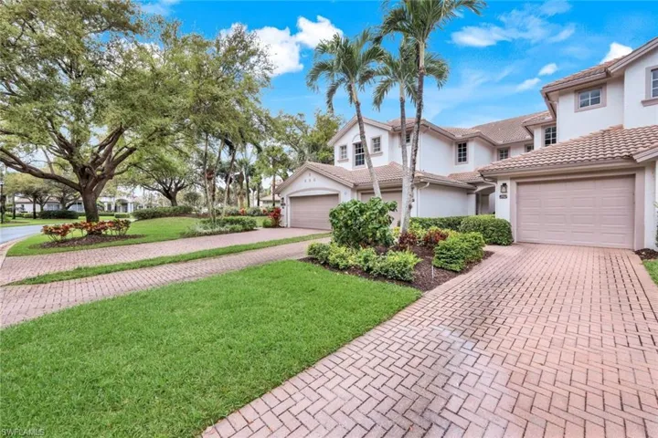 View of front facade with a garage, stucco siding, decorative driveway, and a front lawn