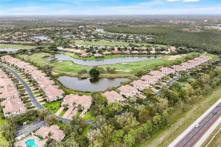 View of property location featuring nearby suburban area, a nearby body of water, and a golf course