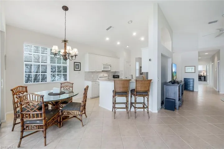 Dining area featuring a chandelier, light tile patterned floors, and recessed lighting