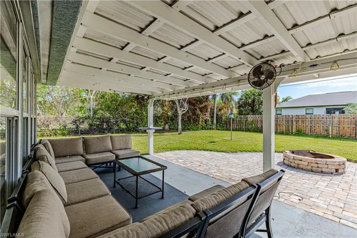 View of patio featuring ceiling fan and an outdoor living space with a fire pit