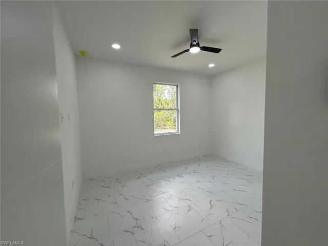 Unfurnished room with recessed lighting, ceiling fan, and marble look tiles