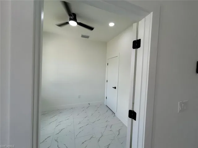 Empty room with light marble finish flooring, ceiling fan, and recessed lighting