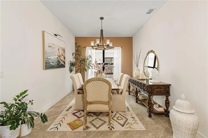 Dining space with a chandelier and baseboards