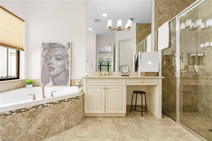 Bathroom with vanity, a bath, a shower stall, a chandelier, and recessed lighting