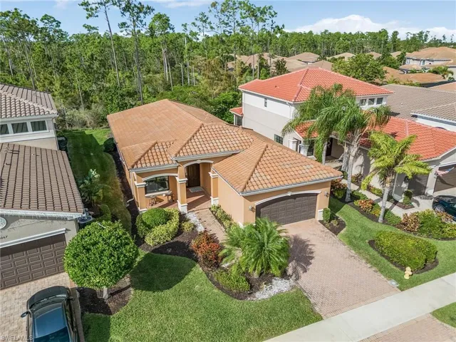 View of front of home featuring a tiled roof, stucco siding, an attached garage, a residential view, and driveway