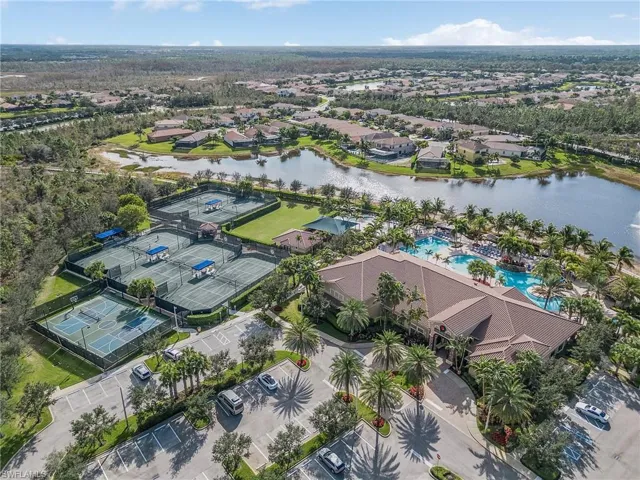 Aerial view of residential area with a nearby body of water and a pool area