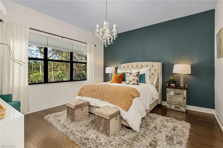 Bedroom featuring a chandelier and dark wood-style flooring
