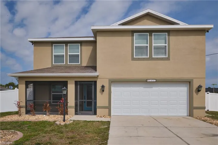 Traditional-style home featuring stucco siding, a sunroom, concrete driveway, and a garage
