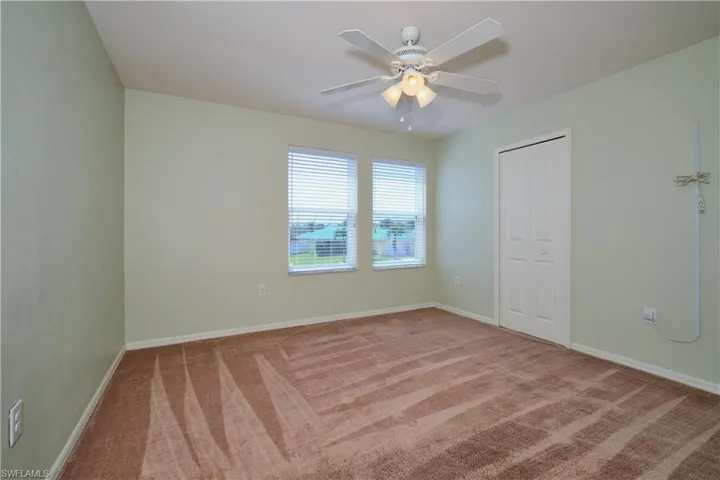 Unfurnished bedroom featuring ceiling fan, carpet floors, and a closet