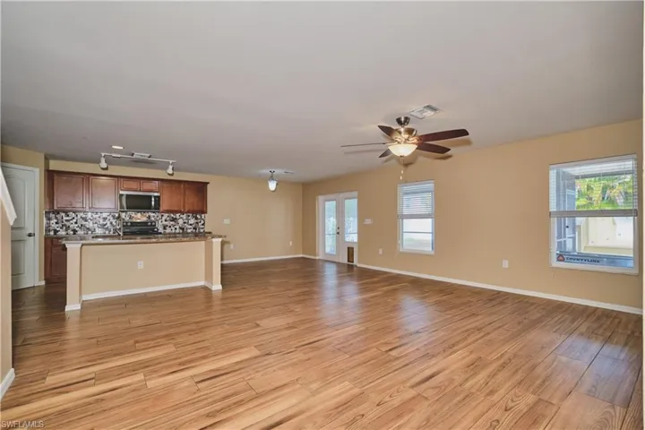 Unfurnished living room featuring light wood-type flooring and ceiling fan