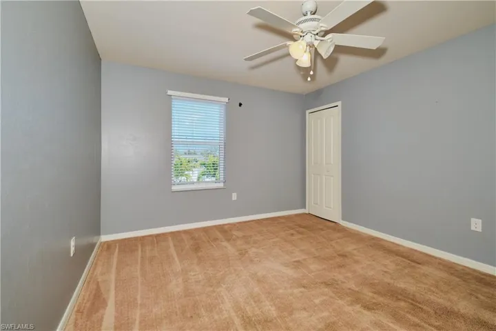 Spare room featuring light colored carpet and ceiling fan