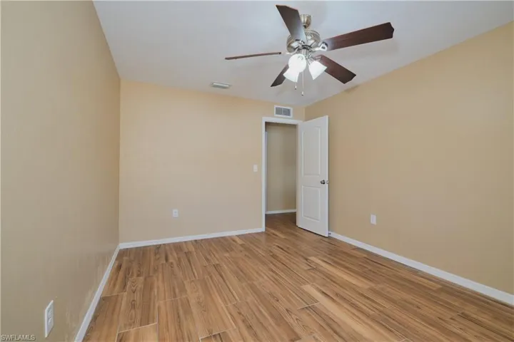 Empty room with a ceiling fan and wood finish floors