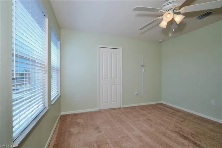 Spare room featuring carpet and ceiling fan