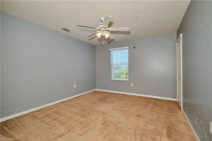 Unfurnished room featuring light colored carpet and a ceiling fan