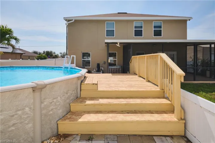 Rear view of property featuring a wooden deck and stucco siding