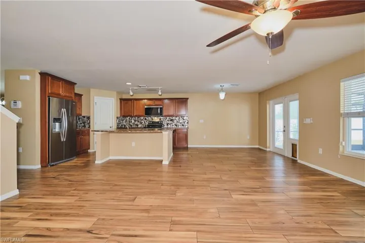 Unfurnished living room with light wood-style flooring and a ceiling fan