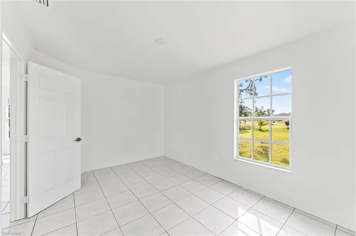 Unfurnished room with light tile patterned floors