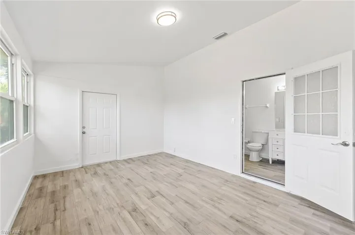 Bonus room / In-law suite featuring light hardwood / wood-style floors and vaulted ceiling. Seperate side entrance, along with full private bathroom.