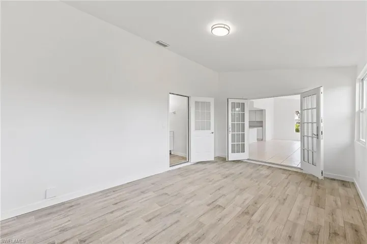 Bonus room / In-law suite featuring light hardwood / wood-style floors and vaulted ceiling. Seperate side entrance, along with full private bathroom.