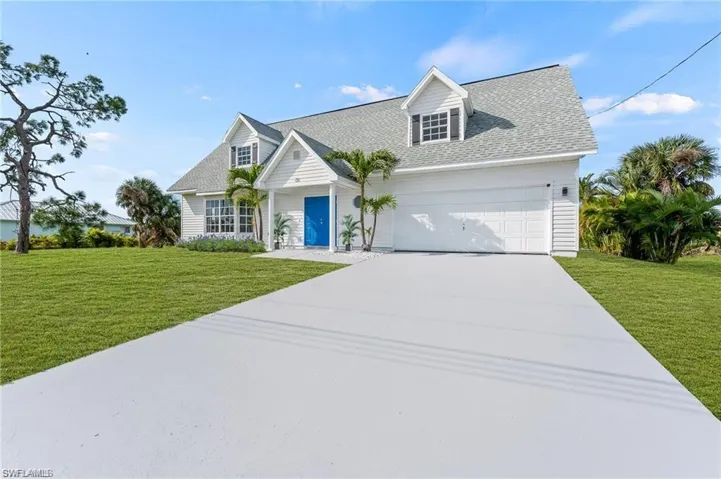 Cape Cod style home with a front yard and a garage