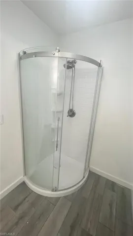 Bonus room / In-law suite shower with door. Bathroom with tiled / wood-style floors