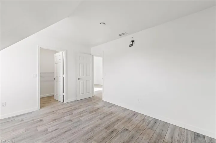 Bedroom featuring a spacious closet, a closet, and light tiled / wood-style floors