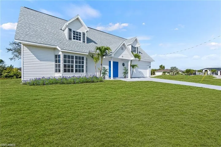 Cape Cod style home with a front yard and a garage