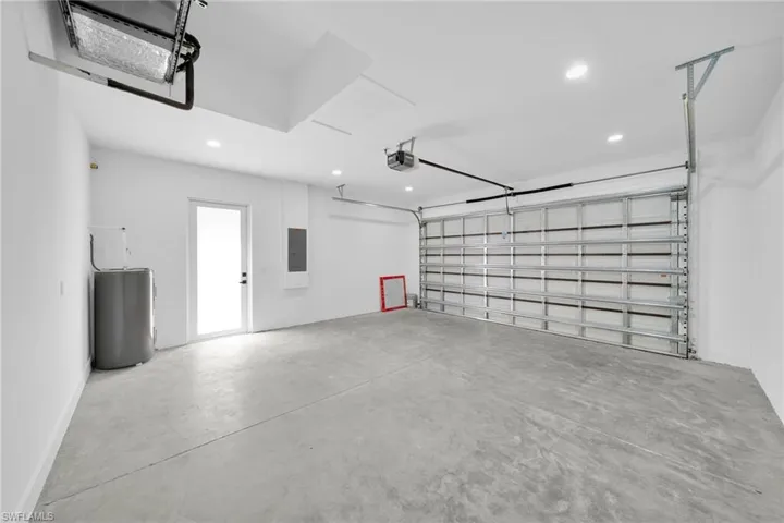 Garage featuring recessed lighting, electric panel, and a garage door opener