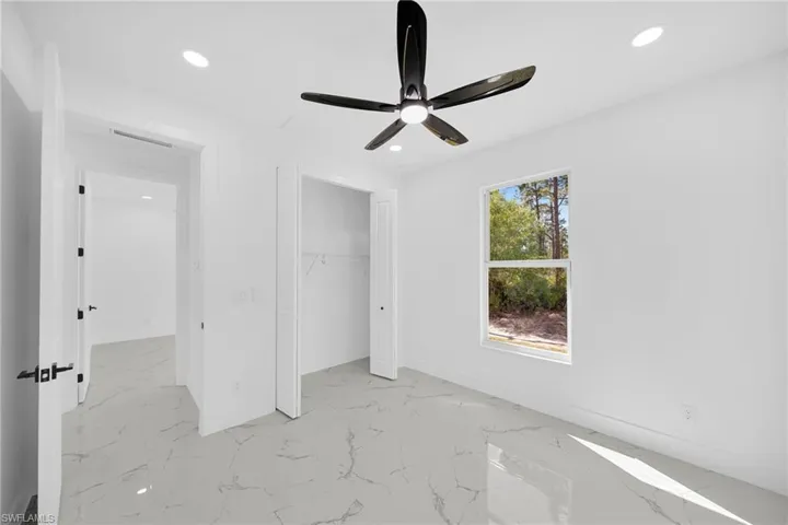 Unfurnished bedroom with light marble finish floors, recessed lighting, ceiling fan, and a closet