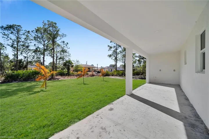 View of grassy yard featuring a patio area